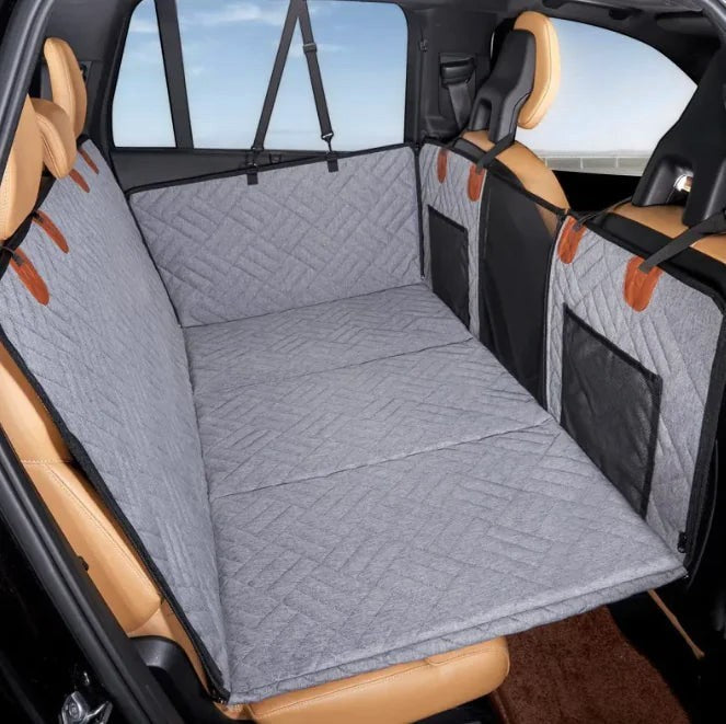 Wooofly waterproof grey quilted dog car seat bed with side bolsters and headrest anchors installed in a vehicle.