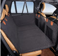 Wooofly waterproof dog car seat bed in black with quilted texture and adjustable headrest straps installed in a car.