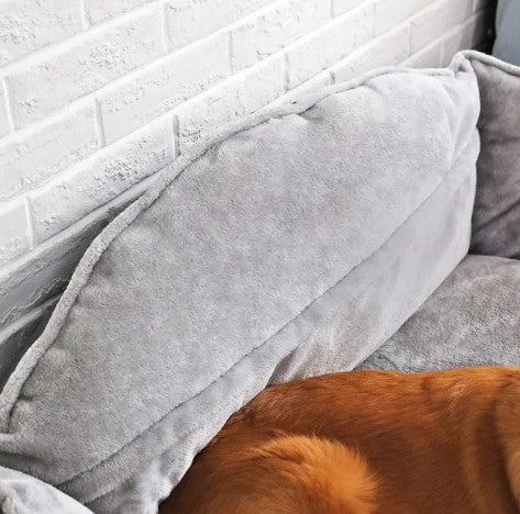 Wooofly stone-grey bolster dog sofa bed with raised sides and soft fabric, featuring a resting brown dog.